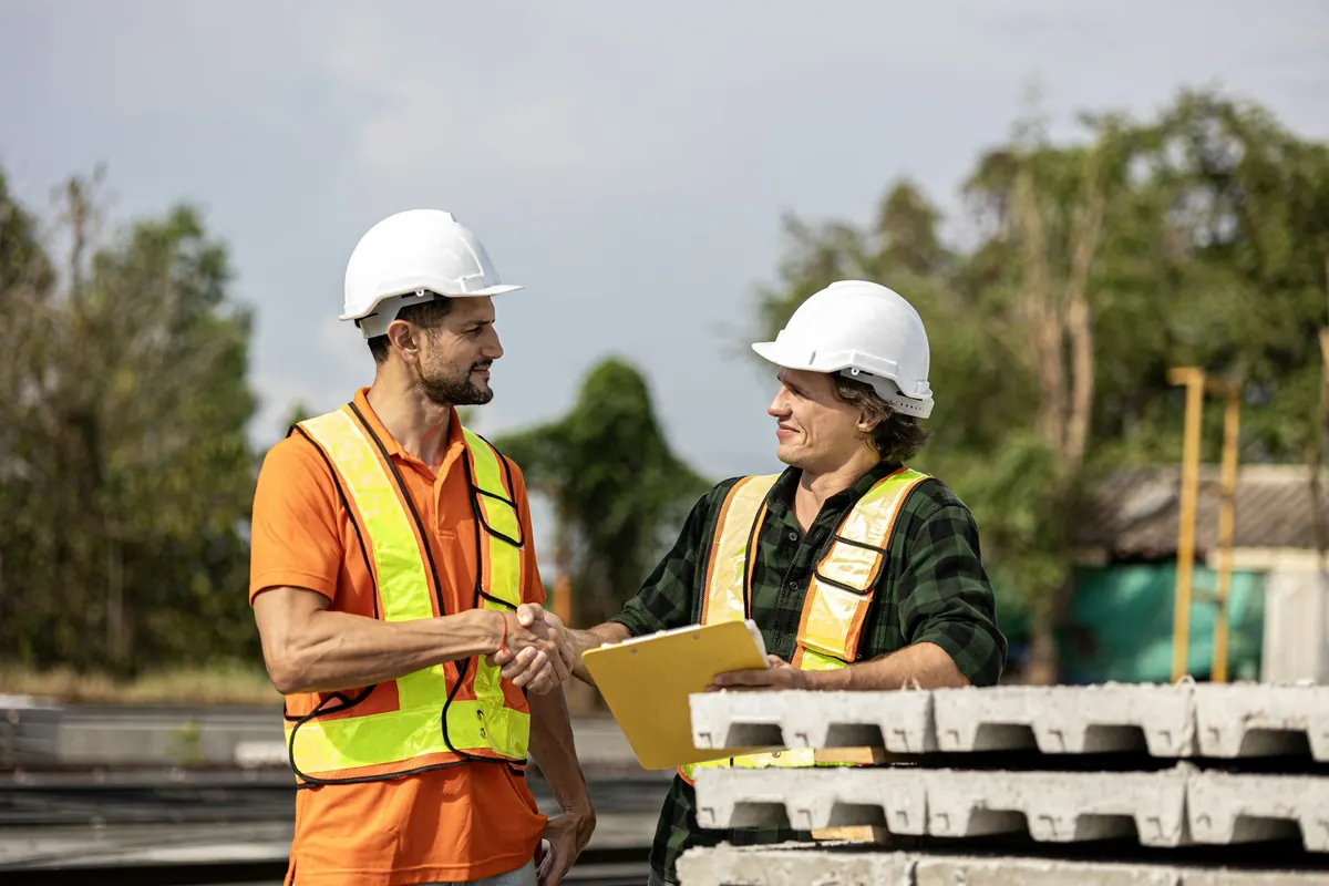 Contractor shaking hands with a project manager on a job site