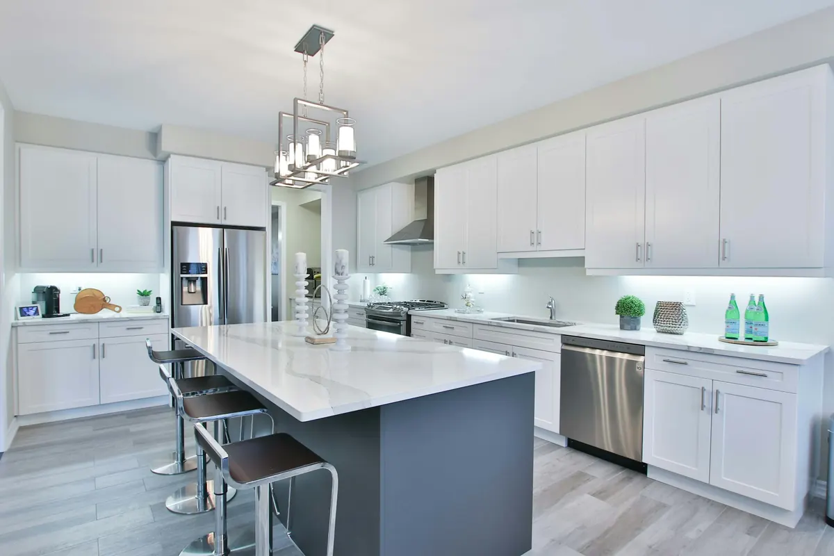 Remodeled kitchen with white cabinets, dark island and stainless appliances